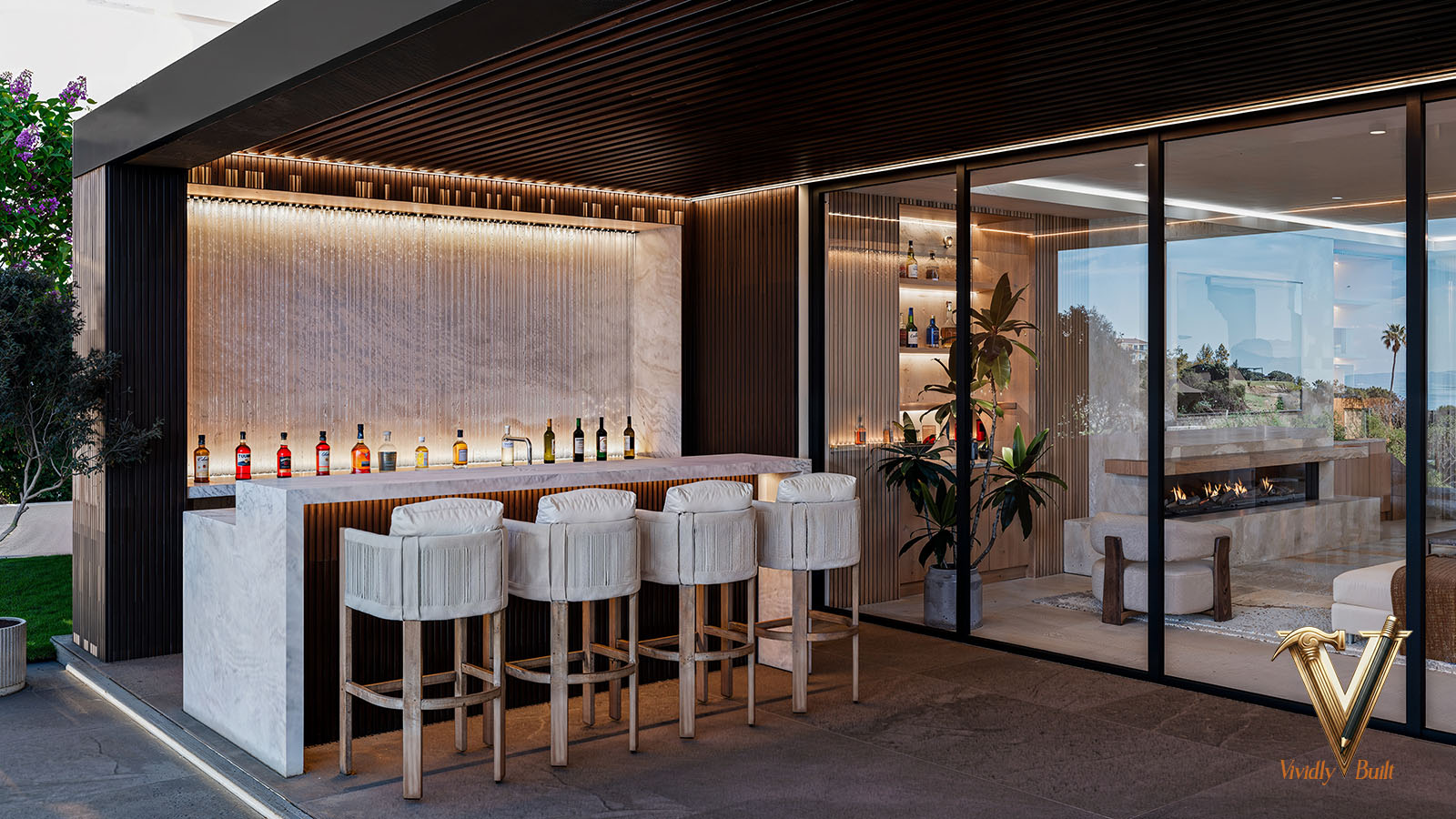 Covered outdoor bar in marble and dark timber, open to the pool deck - Palos Verdes estate by Vividly Built